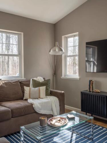 a living room with a couch and a glass table at Private Cabin with Guesthouse Hot Tub Fire Pits in Roscoe