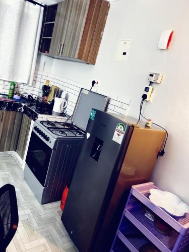 a kitchen with a black refrigerator and a stove at Tulivu Apartment in Nairobi
