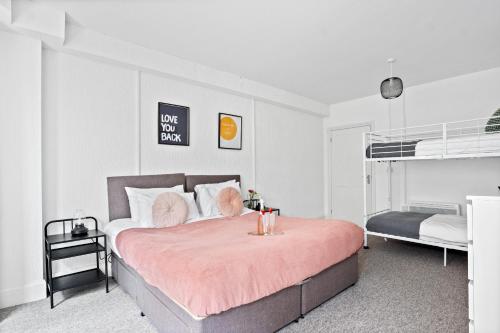a bedroom with a bed with a pink blanket at Spacious Family Apartment, Sleeps 6, FREE Secure Parking, Near Beach in Bournemouth