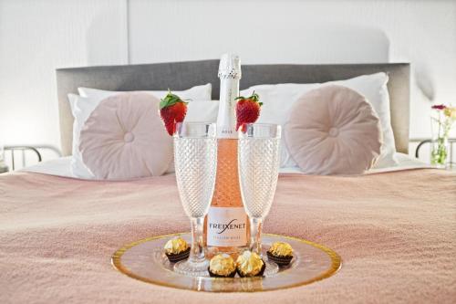 a bottle of champagne and strawberries on a bed at Spacious one bed Apartment, contractor friendly, Sleeps 6, FREE Secure Parking, Near Beach in Bournemouth
