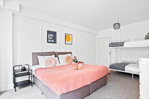 a bedroom with a large bed with a pink blanket at KGV Stays - Central Family Apartment, Sleeps 6, 7 Minute Walk to Beach, PET friendly in Bournemouth
