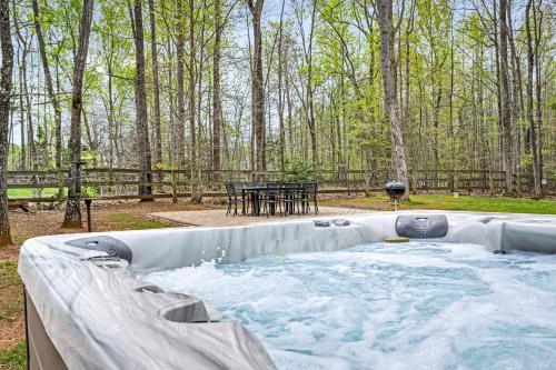 a hot tub in a backyard with a picnic table at Lake House with Hot Tub and Fire Pit in Bumpass
