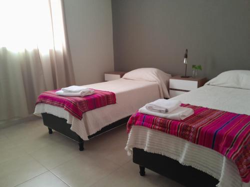 a bedroom with two beds and a window at Las Bahuinias in San Fernando del Valle de Catamarca