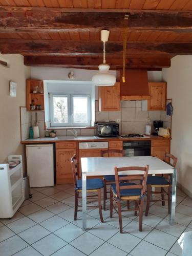 une cuisine avec une table et des chaises dans une pièce dans l'établissement LA TRUFFIERE, à Castelnau-de-Mandailles