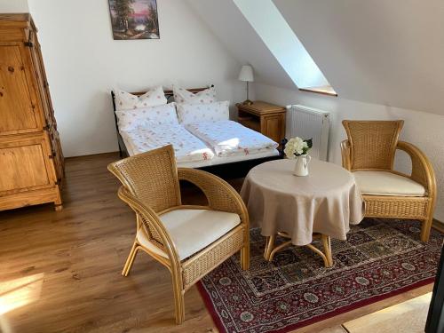 a bedroom with a bed and two chairs and a table at Pension zum Zenshaus kleine Auszeit in Lychen