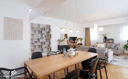 Una sala de estar con una mesa y sillas de madera. en Fancy 2BR Pipera Apartment, en Voluntari