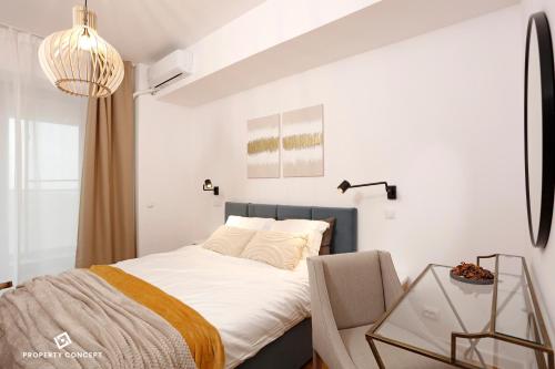 Un dormitorio con una cama y una mesa de cristal. en Fancy 2BR Pipera Apartment, en Voluntari