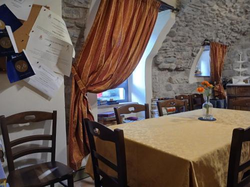 a dining room with a table and chairs and a window at Eremo Gioioso in Pontremoli