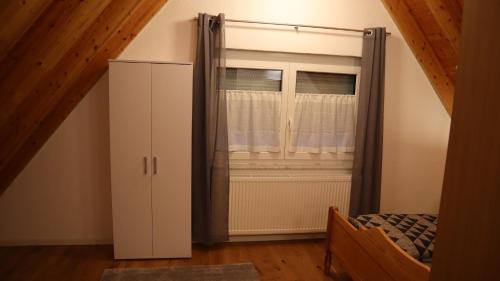 a bedroom with a window and a bed and a cabinet at Toskana in Klingenmünster