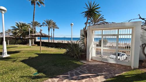 a gate at the beach with the ocean in the background at Playa y montaña 1ª linea Piscina Parking AC in El Campello