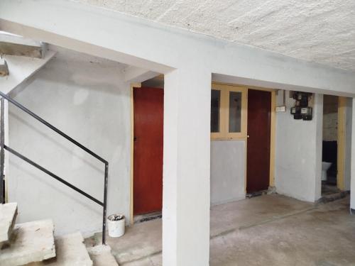 an empty room with three doors and stairs at Holy Spirit Mission Camps in Mount Lavinia