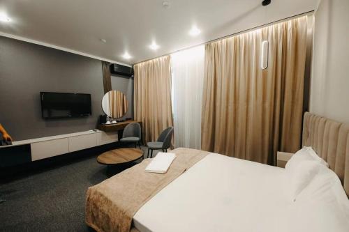 a hotel room with a bed and a television at Irislux in Taraz