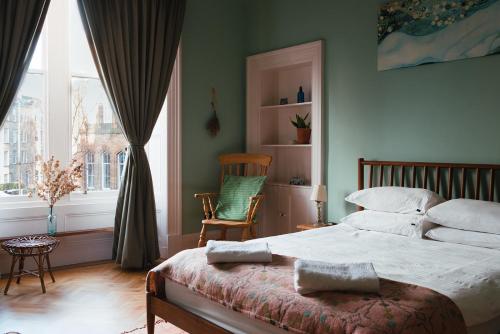 une chambre avec un lit, une chaise et une fenêtre dans l'établissement Beautiful central Edinburgh Apartment, à Édimbourg
