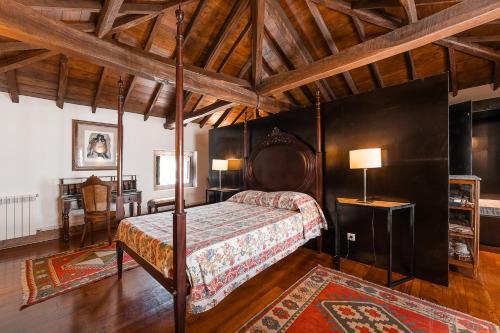 a bedroom with a canopy bed in a room with wooden ceilings at Casa do Lagar in Cabeceiras de Basto
