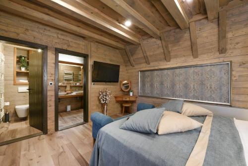 a bedroom with a blue bed and a bathroom at Lakeside Hotel Plitvice in Plitvička Jezera