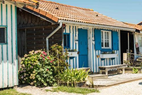 a blue and white house with a bench and flowers at Villa Romance in Audenge