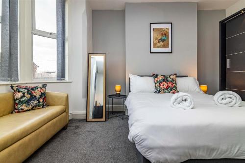 a bedroom with two beds and a couch at Motorpoint Arena House - Sleeps 10 in Nottingham