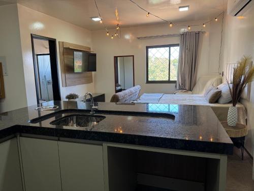 a kitchen with a sink and a living room at Prédio Green Hall in Toledo
