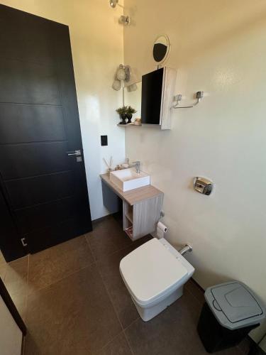 a bathroom with a white toilet and a sink at Prédio Green Hall in Toledo