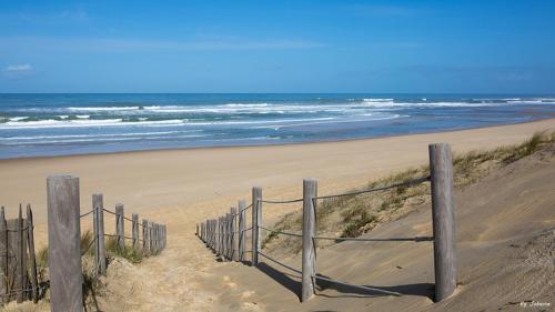 a wooden fence on a beach with the ocean at Villa Romance in Audenge