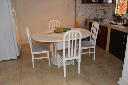 a kitchen with a table and chairs with a bowl of fruit on it at Résidence Hotelière Borel Denver in Douala