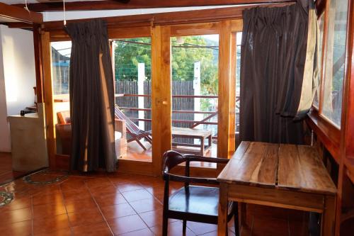 a wooden table and chair in a room with a balcony at Nuestra Casa in San Juan del Sur