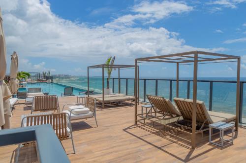 a deck with chairs and a view of the ocean at ArtStudio Open Spaces in Salvador
