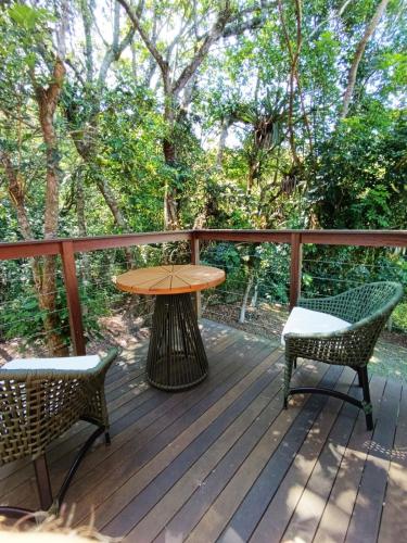 a wooden deck with a table and two chairs at Studio Ágata - Praia do Silveira - Garopaba in Garopaba