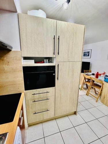 - une cuisine avec des placards en bois et un four micro-ondes dans l'établissement Kap'Lor, au Guilvinec