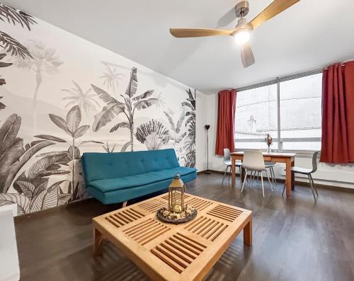 un salon avec un canapé bleu et une table dans l'établissement Charmant Duplex Hyper Centre Nancy, à Nancy