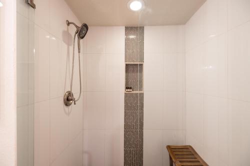 a bathroom with a shower with a clock on the wall at Gilbert East Laurel in Gilbert
