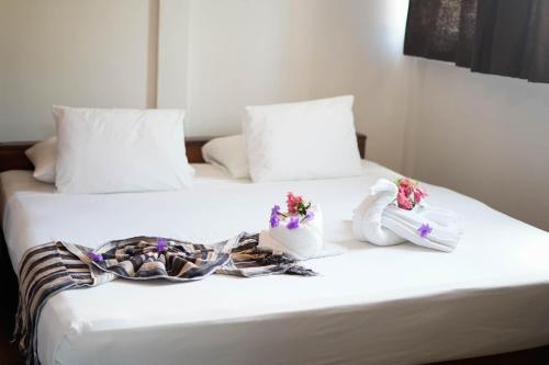 a couple of beds with towels and flowers on them at Nuestra Casa in San Juan del Sur