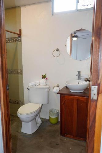 a bathroom with a toilet and a sink and a mirror at Nuestra Casa in San Juan del Sur