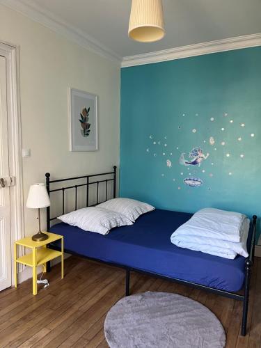 - 2 lits dans une chambre avec un mur bleu dans l'établissement Cozy pavillon quartier Laplace, Maison des examens, à Arcueil