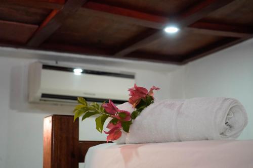 a roll of paper towels with flowers on top of a bed at Nuestra Casa in San Juan del Sur