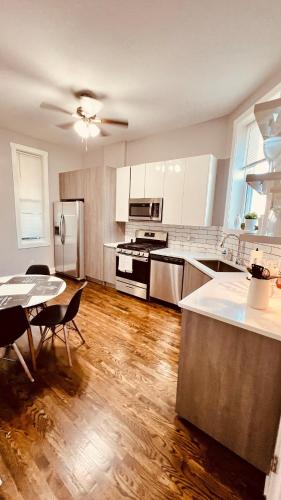 une cuisine avec des armoires blanches et un plancher en bois dans l'établissement Modern Pilsen Chicago Apartment 2 bedroom, à Chicago