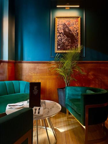 a room with blue and green furniture and a table at Tait House by Bower Boutique Hotels in Shediac