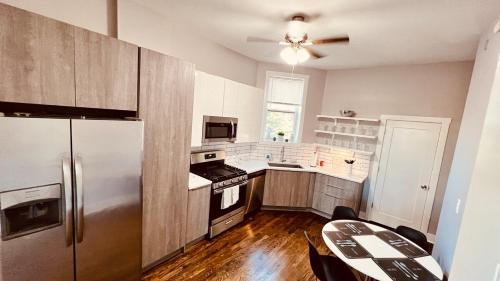 une cuisine avec un réfrigérateur et une table à l'intérieur dans l'établissement Modern Pilsen Chicago Apartment 2 bedroom, à Chicago