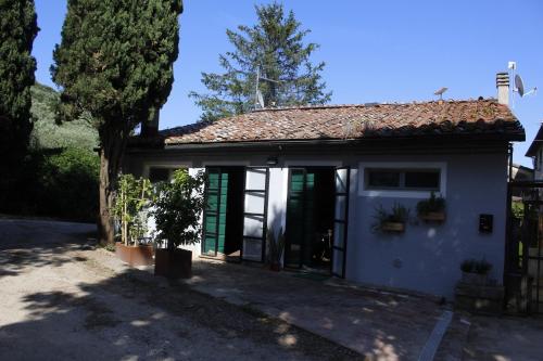 a white house with a door and a tree at Pub house in Lucca
