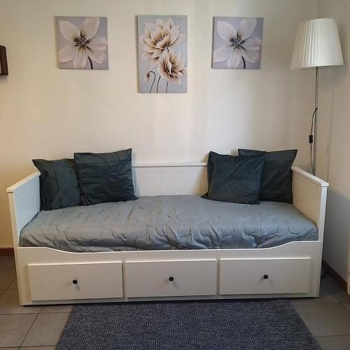 a bed in a room with flowers on the wall at Monolocale Antica Argenteria II a pochi passi dalla stazione e dal centro in Vercelli