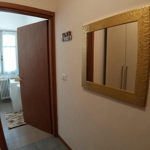 a bathroom with a large mirror and a door at Monolocale Antica Argenteria II a pochi passi dalla stazione e dal centro in Vercelli