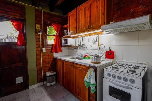 Una pequeña cocina con estufa y fregadero. en Brisas del Sur, en El Bolsón