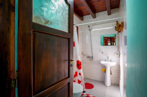 Un baño con inodoro, lavabo y puerta. en Brisas del Sur, en El Bolsón