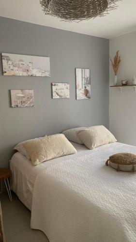 une chambre avec un grand lit avec des draps blancs dans l'établissement Appartement neuf, parking et terrasse Proche Vélodrome, à Marseille