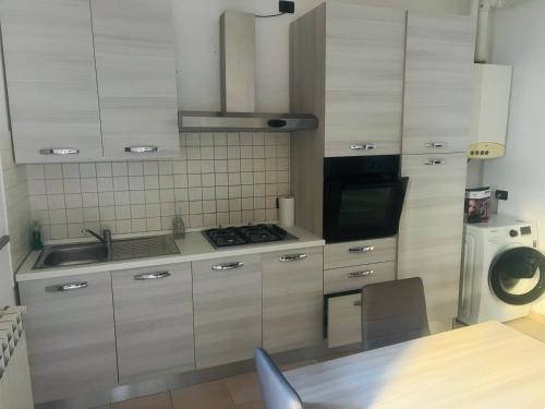 a kitchen with a sink and a stove top oven at Via Brescia in Cremona