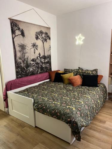 a bedroom with a bed with a floral bedspread at Studio indépdt centre ville 300m du lac d’Annecy in Veyrier-du-Lac