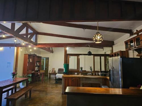 a large kitchen with wooden ceilings and a dining room at Nuestra Casa in San Juan del Sur