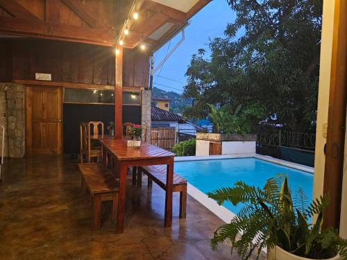 a patio with a table and a swimming pool at Nuestra Casa in San Juan del Sur