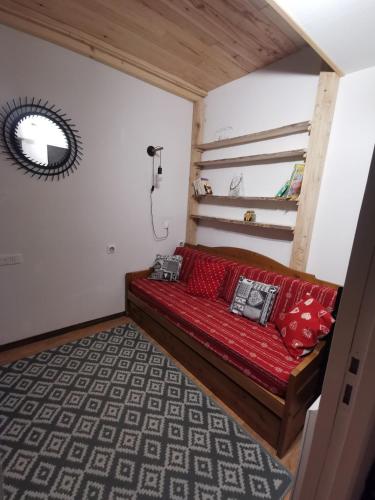 - un canapé rouge dans une chambre avec fenêtre dans l'établissement Appartement refait à neuf pour 8 personnes à Albiez-Montrond, à Albiez-Montrond