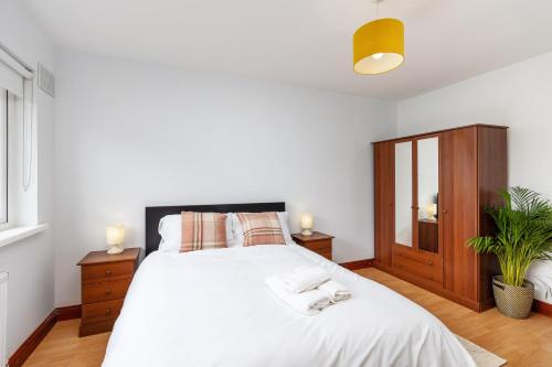 a bedroom with a large white bed and a window at Dublin City Centre Modern 3 Bedroom House in Dublin
